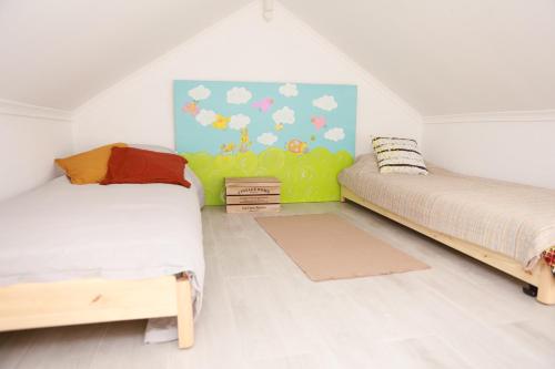 a bedroom with two beds and a painting on the wall at Monte da Masmorra de baixo-Casa Alentejana in Montemor-o-Novo