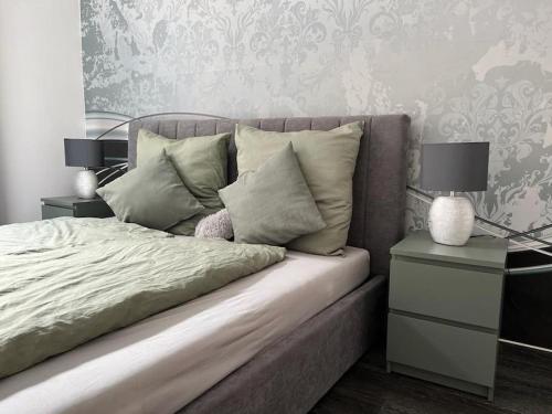 a bedroom with a bed with two end tables and two lamps at City Vibe Zentrum Zwickau in Zwickau