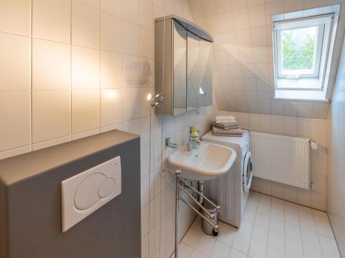 y baño con lavabo y lavadora. en Cozy apartment in Herrischried in a charming area, en Herrischried