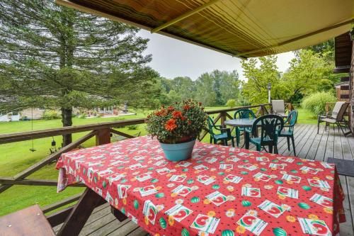 a table with a red table cloth on a deck at Pet-Friendly Jamestown Cabin with Fire Pit and Deck! in Jamestown
