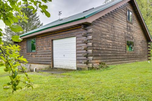 a log cabin with a white garage door at Pet-Friendly Jamestown Cabin with Fire Pit and Deck! in Jamestown