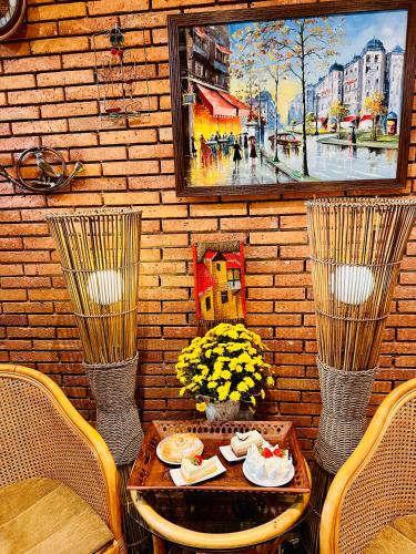 a table with two chairs and a painting on a wall at Hotel British House in Tbilisi City