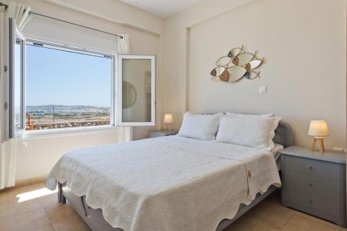 a bedroom with a large bed and a large window at Vento Retreat Villa in Afiartis