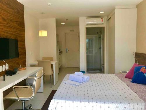 a room with a bed and a desk and a computer at V1118 Maravilhoso flat em hotel de Brasília Central in Brasilia