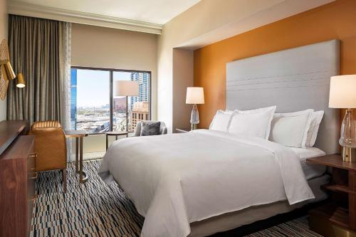a hotel room with a bed and a desk and a window at Hilton Grand Vacations Club on the Las Vegas Strip in Las Vegas