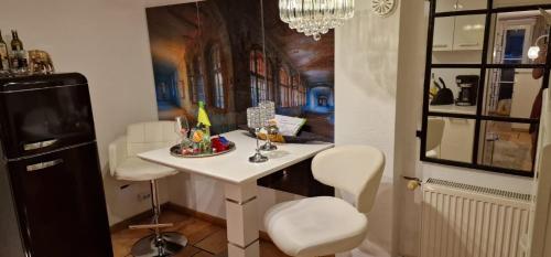 a kitchen with a table and two white stools at Am alten Siel in Wilhelmshaven