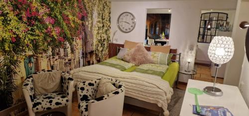 a bedroom with a bed and a table and a clock at Am alten Siel in Wilhelmshaven