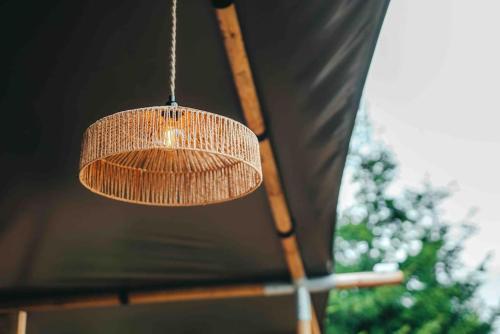 uma luz pendurada no tecto de uma tenda em Cosy Forest Lodge em Penrhôs