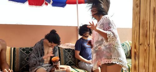 a group of people sitting on a couch at Atlantic Vibes Surf Hostel in Tamraght Ouzdar