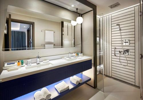 a bathroom with two sinks and a mirror at Hilton London Heathrow Airport in Hillingdon