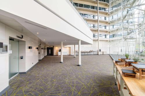 an empty office with tables and chairs in a building at Hilton London Heathrow Airport in Hillingdon