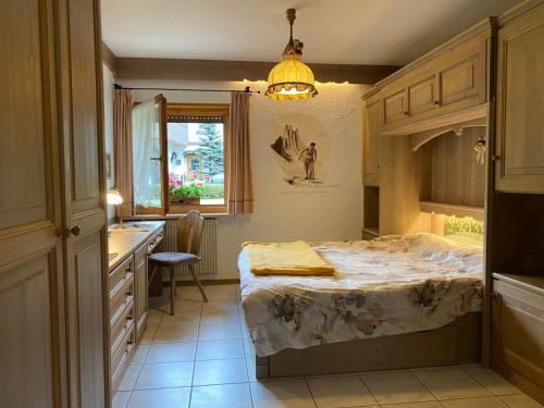a room with a bed in a kitchen with a sink at Residence Lastè in Moena