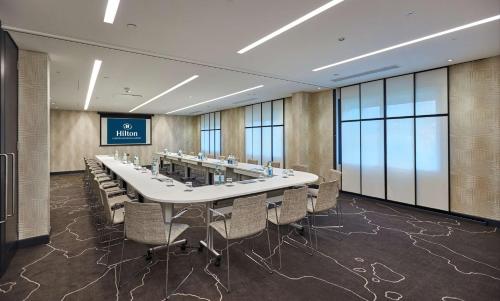 a large conference room with a long table and chairs at Hilton London Heathrow Airport in Hillingdon
