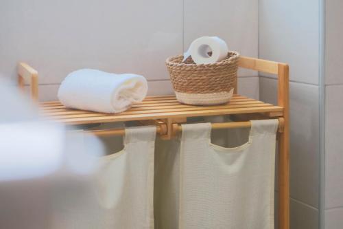 un portasciugamani con asciugamani e un rotolo di carta igienica di La Casita Nazaré - private pool a Nazaré