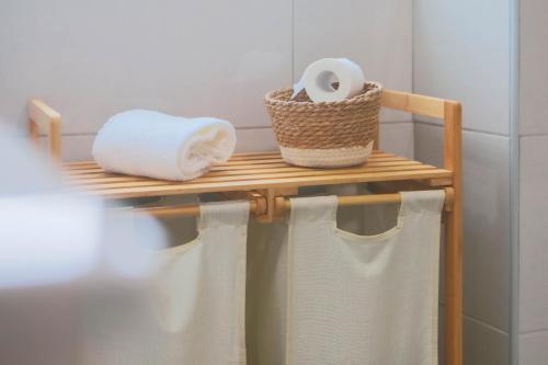 a towel rack with towels and a roll of toilet paper at La Casita Nazaré - private pool in Nazaré