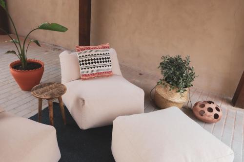 una sala de estar con muebles blancos y macetas. en La Casita Nazaré - private pool, en Nazaré