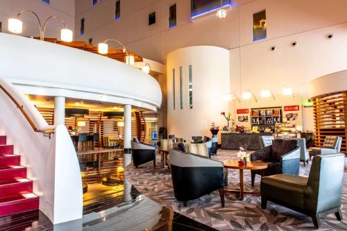 a lobby of a restaurant with tables and chairs at Hilton London Heathrow Airport Terminal 5 in Hillingdon