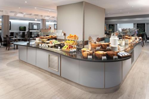 a buffet line with food on it in a restaurant at Hilton London Kensington Hotel in London