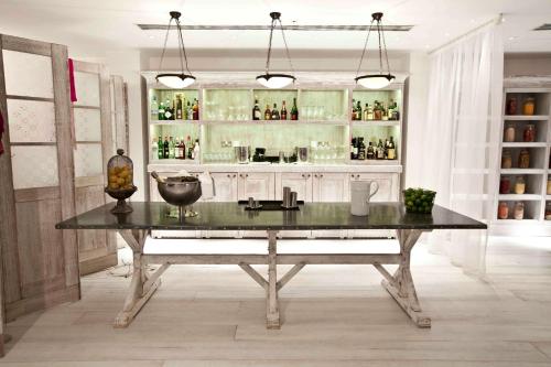 a table in a room with a bar with bottles at Hilton London Heathrow Airport Terminal 5 in Hillingdon