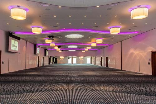 a long hallway with purple lights on the ceilings at Hilton London Heathrow Airport Terminal 5 in Hillingdon