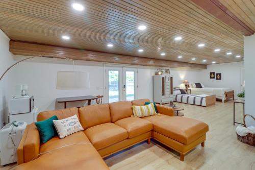 a living room with a brown couch and a room with a bed at Greers Ferry Hideaway Lake View, Boat Ramp Access in Fairfield Bay