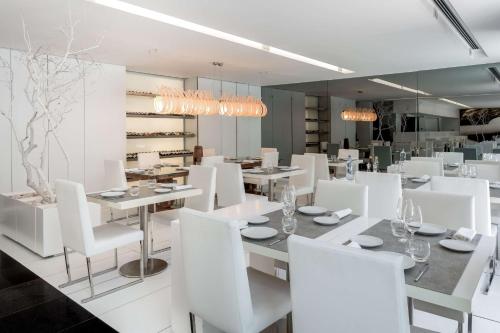 a dining room with white tables and white chairs at DoubleTree by Hilton Lisbon Fontana Park in Lisbon