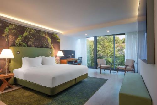 sypialnia z dużym białym łóżkiem i biurkiem w obiekcie DoubleTree by Hilton Lisbon Fontana Park w Lizbonie
