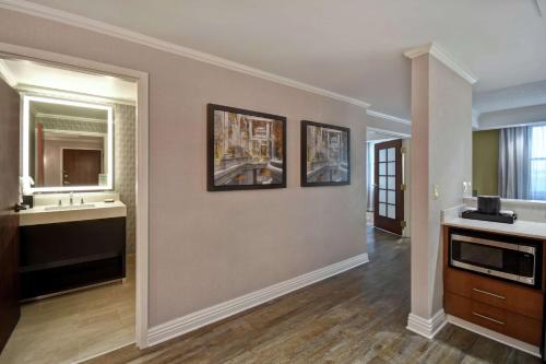 a living room with two pictures on the wall at Embassy Suites Little Rock in Little Rock