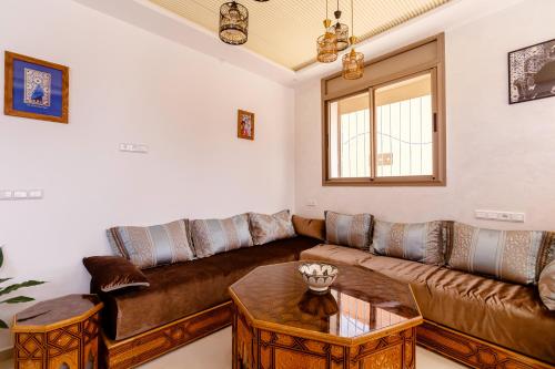 a living room with a couch and a table at Atlantic Vibes Surf Hostel in Tamraght Ouzdar
