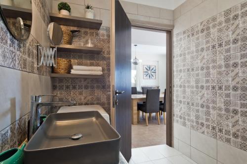 een badkamer met een wastafel en een tafel bij Vènto villa in Karpathos