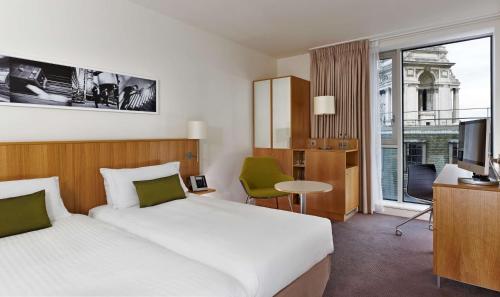 a hotel room with a bed and a large window at DoubleTree by Hilton Hotel London - Tower of London in London