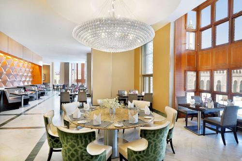 a dining room with a table and chairs and a chandelier at Hilton Suites Jabal Omar Makkah in Makkah