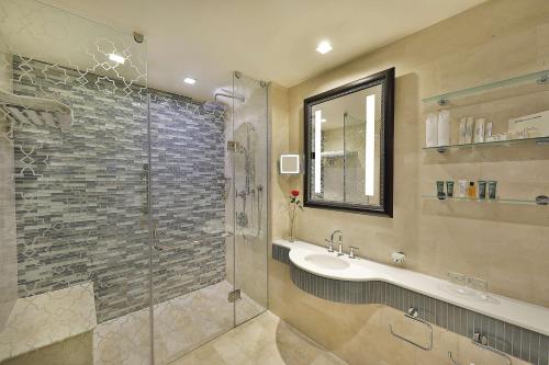 a bathroom with a sink and a glass shower at Hilton Suites Jabal Omar Makkah in Makkah