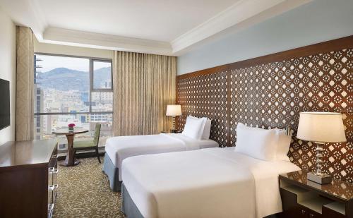 a hotel room with two beds and a window at Hilton Suites Jabal Omar Makkah in Makkah
