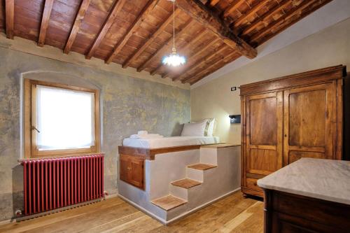 1 dormitorio con cama, ventana y radiador en La Pimpinella di Semifonte, en San Donnino