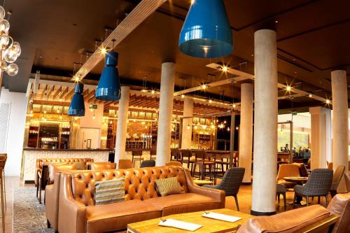 a restaurant with couches and tables and blue lights at DoubleTree by Hilton Manchester Piccadilly in Manchester