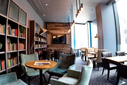a restaurant with tables and chairs and bookshelves at DoubleTree by Hilton Manchester Piccadilly in Manchester