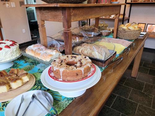 a table filled with different types of cakes and pastries at Hotel Pousada Parque das Águas in Olímpia