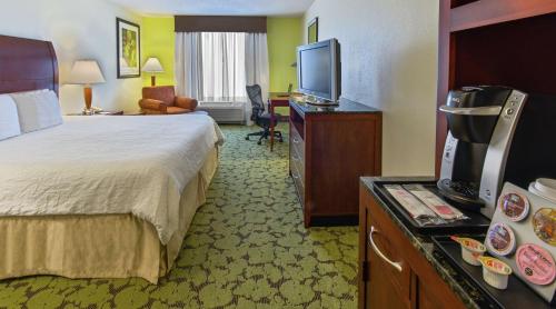 um quarto de hotel com uma cama e uma televisão de ecrã plano em Hilton Garden Inn Macon/Mercer University em Macon