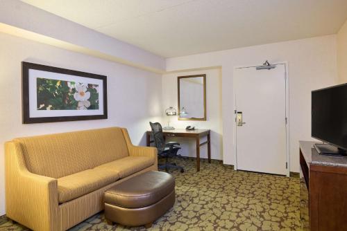 a hotel room with a couch and a desk at Hilton Garden Inn Hershey in Hummelstown