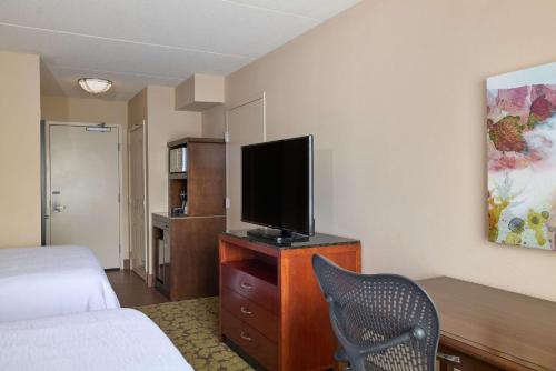 a hotel room with a bed and a television on a dresser at Hilton Garden Inn Hershey in Hummelstown