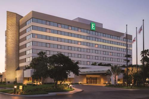 a large building with a green sign on it at Embassy Suites by Hilton Orlando International Drive ICON Park in Orlando