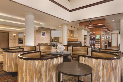 a restaurant with tables and chairs in a lobby at Embassy Suites by Hilton Orlando International Drive ICON Park in Orlando
