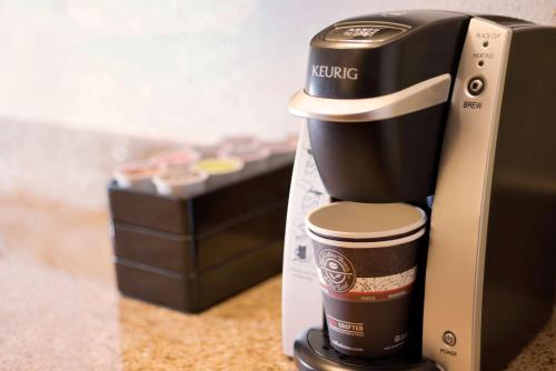 a coffeemaker sitting next to a cup of coffee at Embassy Suites by Hilton Orlando International Drive ICON Park in Orlando