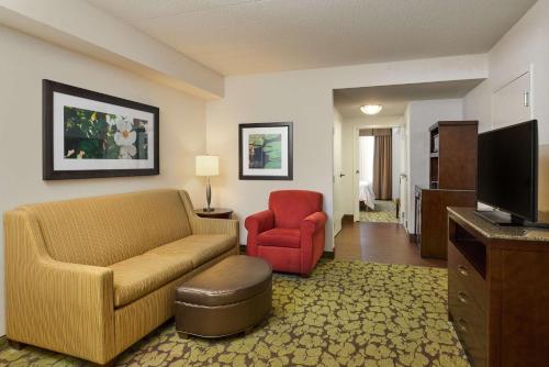 a living room with a couch and a red chair at Hilton Garden Inn Hershey in Hummelstown