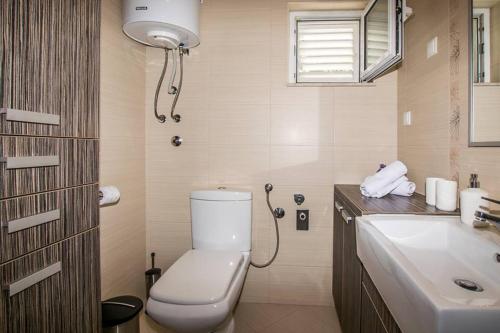 ein Bad mit einem WC und einem Waschbecken in der Unterkunft Apartman Antea in Trogir