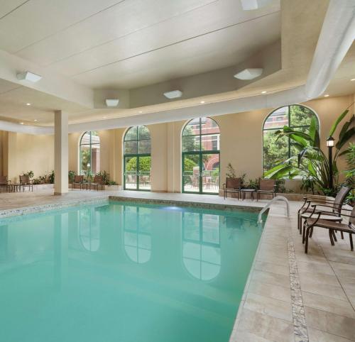 a large pool with blue water in a building with windows at Embassy Suites Montgomery - Hotel & Conference Center in Montgomery