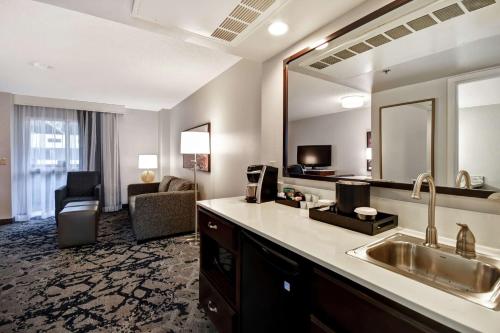 a hotel room with a sink and a large mirror at Embassy Suites Montgomery - Hotel & Conference Center in Montgomery