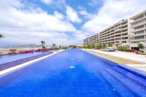 a large blue swimming pool next to a building at Hermosa vista al Arco de Cabo in Cabo San Lucas