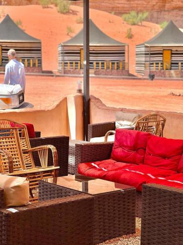a red couch sitting on top of wicker chairs at RUM STARDUST lUXURY CAMP in Wadi Rum